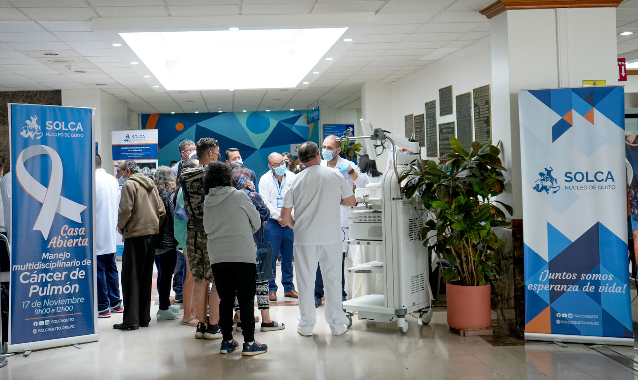 Salón con rollups desplegados y gente escuchando a los doctores